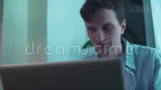 一个人坐在窗边打笔记本电脑视频
