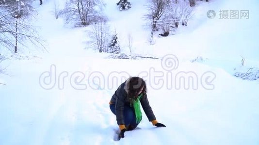 白雪皑皑的公园里的年轻快乐的女人。 那个女人用手拿着雪，把它扔到空中。 一个女人视频