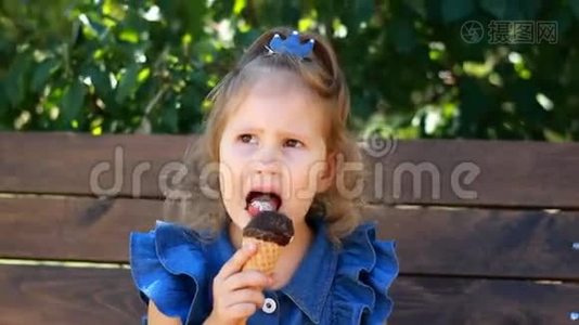 小女孩在阳光明媚的夏天在公园里吃冰淇淋和巧克力。 婴儿特写肖像视频