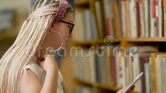 年轻的金发碧眼，图书馆里有一块平板电脑视频