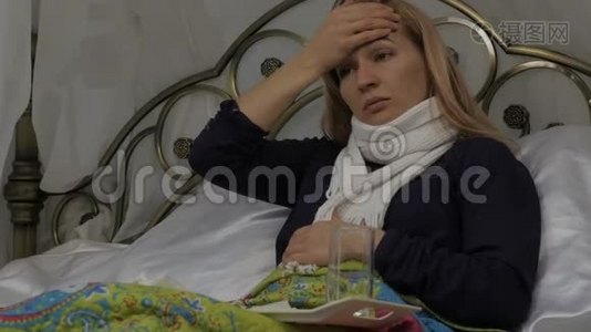 生病的女人咳嗽喝了一片药。 女孩躺在床上，脖子上戴着一条温暖的围巾。 4K视频
