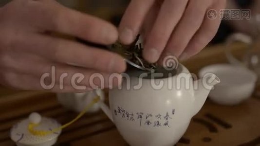 中国茶道，手把茶叶放进茶壶，特写拍摄。视频