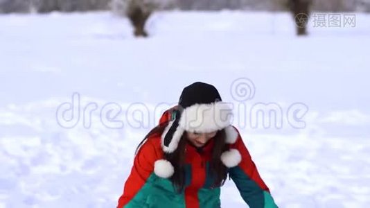 白雪皑皑的公园里的年轻快乐的女人。 那个女人用手拿着雪，把它扔到空中。 一个女人视频
