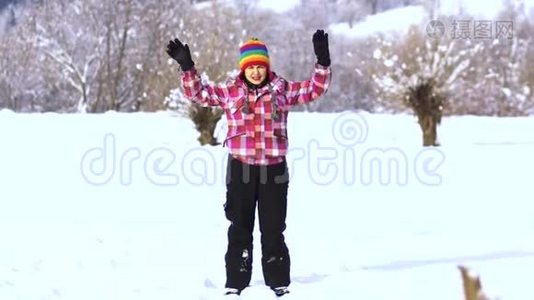 白雪皑皑的公园里的年轻快乐的女人。 那个女人用手拿着雪，把它扔到空中。 一个女人视频