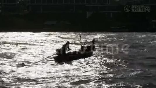 一艘小木渔船的剪影，渔民们在海边活动。 泰国。 亚洲视频
