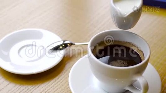旋转的牛奶倒入一杯咖啡中。 卡布奇诺制剂视频