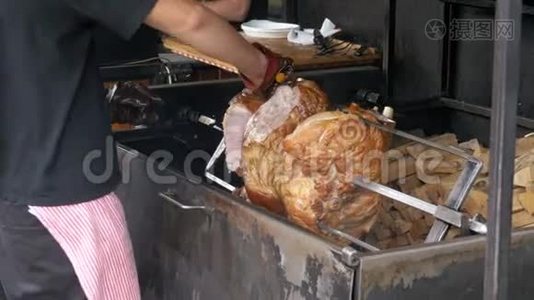 大块肉肉，烤猪肉腿准备在一个叉以上的明火。 捷克共和国布拉格的街头美食..视频