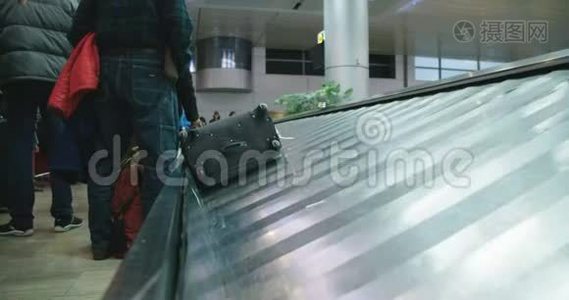 从机场传送带上收集行李的乘客视频