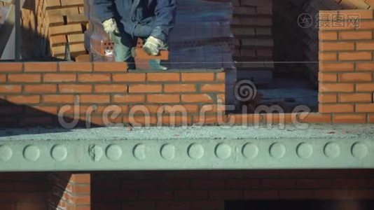 工人砌一堵砖墙. 建筑物上的建筑工人进行砌砖。 建筑工地的建筑工人视频