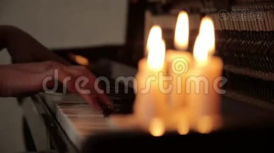 在蜡烛的灯光下，特写女性双手在黑暗中弹钢琴视频
