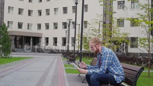 一个年轻的学生来到大学的背景下，打电话，拿着重要的文件视频