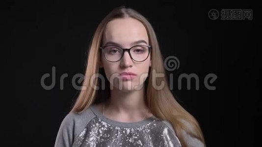 年轻迷人的时髦女性戴着眼镜，直视镜头，背景与黑色隔离视频