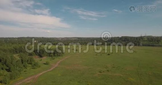 空中观景。 农村公路之间的农田和电力高压支架。 绿色田野之间的乡村道路。 4K视频