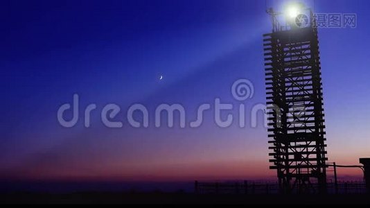 海滩上的木制灯塔，蓝天上的月亮。视频
