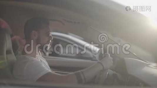 漂亮的纹身青年男子戴着太阳镜，坐在豪华跑车对面，准备开始比赛视频