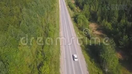 俯视风景蜿蜒的乡村道路穿过绿色农田。 剪辑。 农村公路视频