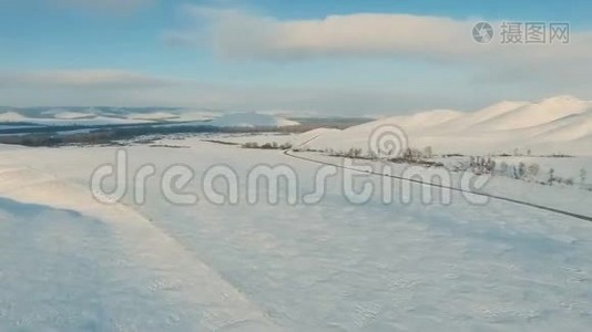 几辆汽车在山上附近的黄昏时分在结冰的道路上行驶。视频