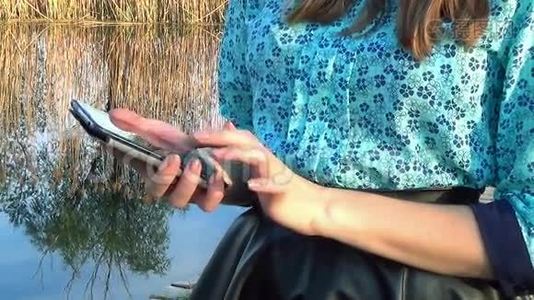 女人在河边用手机视频