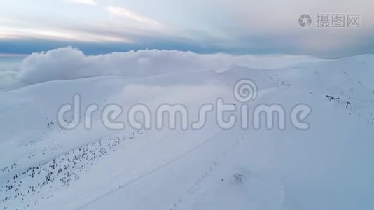 在被黄昏的太阳照亮的雪山上飞行视频