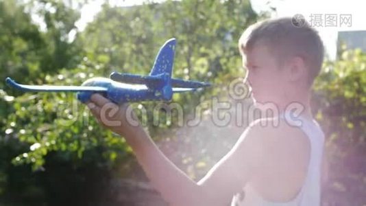 玩得开心。 快乐男孩与飞机手中的运行日落背景。视频