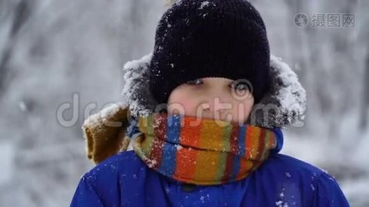 男孩站在外面的雪天气和波浪在相机。视频