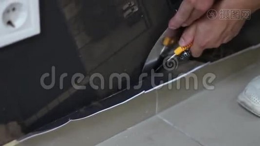 工人在贴墙纸后在地板附近剪墙纸视频