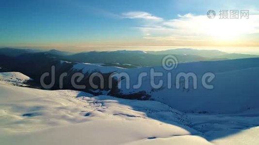 在被黄昏的太阳照亮的雪山上飞行视频