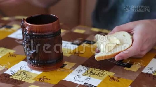 男人正在一杯热咖啡旁边的面包上抹黄油视频