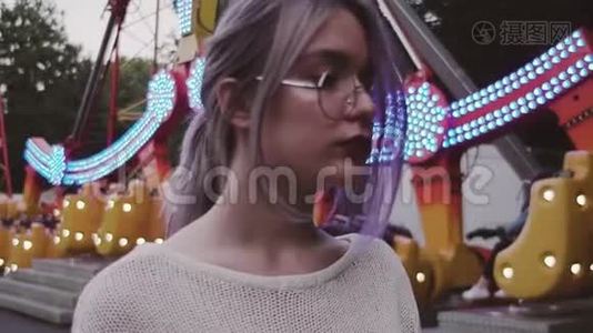 骑着眼镜的年轻女孩站在游乐园的跷跷板附近视频