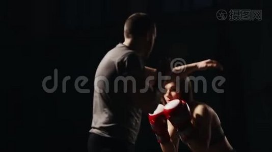 肌肉健身女孩训练与他的教练进行打击脚拳击手套。 自我的教训视频
