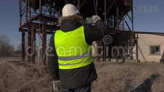 工人在金属罐附近的平板上拍照视频