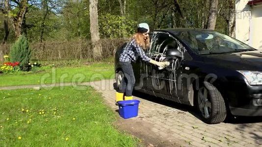 女人用肥皂海绵洗黑车。视频