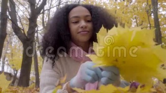 美丽的黑人少年收集黄色的枫叶视频