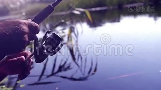 一名男子用鱼竿钓鱼时的饱和镜头视频
