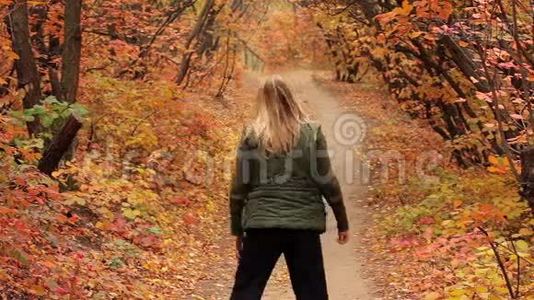 金发女孩在秋天的森林里锻炼视频