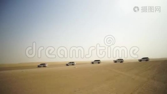 在日落时，在阿拉伯沙漠的越野车和迪拜天际线或城市景观的空中观赏冒险。 沙漠之旅视频