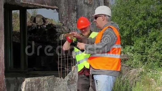 建筑工人在损坏的建筑物附近交谈视频