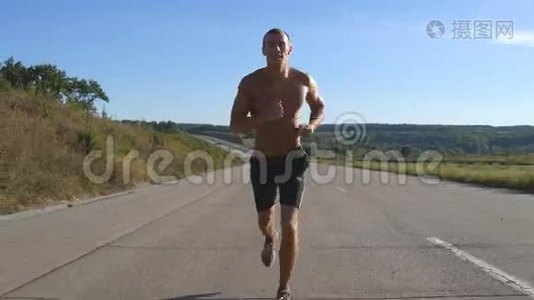 冲刺跑步者在高速公路上慢跑。 男子体育运动员夏季户外训练。 年轻强壮肌肉男视频