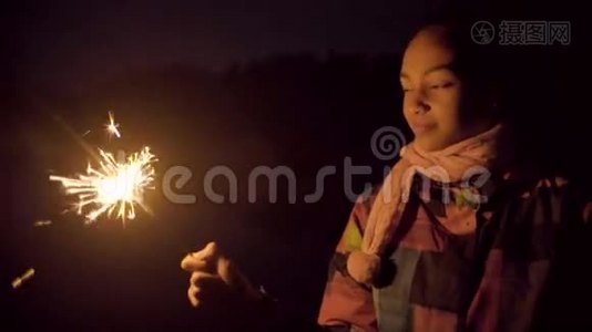 快乐的黑人女孩用火花在空中画线条视频