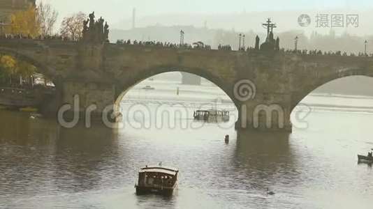 查尔斯桥，查尔斯桥上的游客。 布拉格日落时一艘旅游船的背景视频