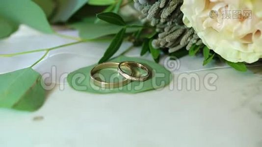 大理石背景的两个金色结婚戒指视频