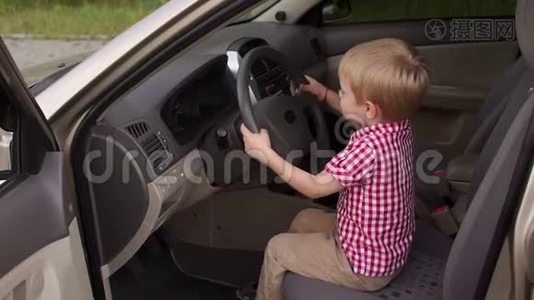 汽车车轮后面一个快乐男孩的肖像。视频