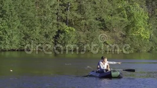两个穿着橡皮船的渔夫在河上划桨。 人在阳光明媚的森林里湖上钓鱼。 斯特拉克河-视频