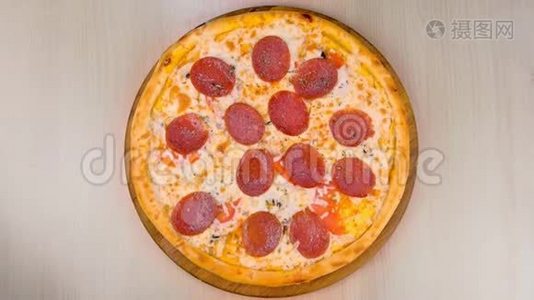 桌子上木板上的萨拉米披萨。 特写俯视图..视频