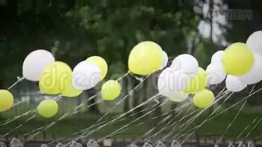 绑在椅子上的白色和黄色气球在风中发展视频