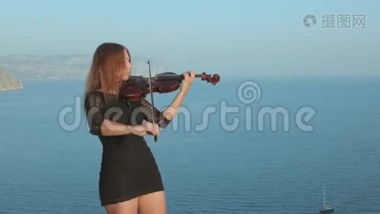穿短裙的女孩站在海边的岩石上视频