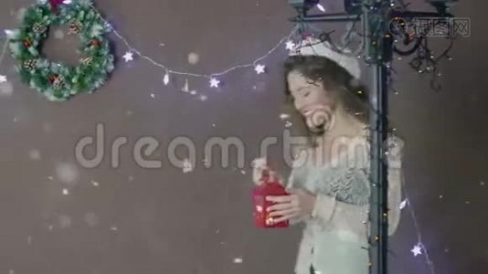年轻漂亮可爱的女孩戴着圣诞帽微笑着，手拿灯笼在圣诞装饰的背景上视频