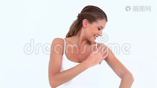 微笑的女人在手臂上涂抹保湿霜视频