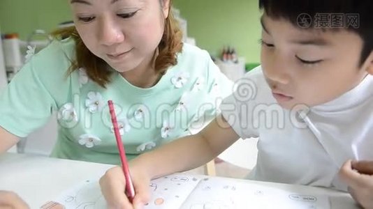 亚洲妈妈正在画她的儿子做学校的作业视频