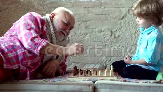 几代人。 孩子玩国际象棋。 爷爷和孙子下棋。 爷爷和孙子下棋。视频